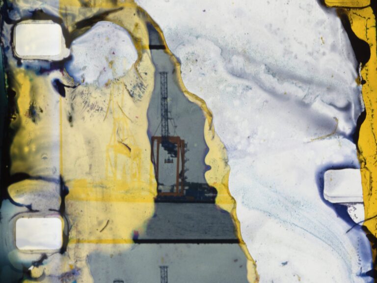 Abstract film image showing a harbor crane through a torn, textured surface, related to a proximity study.