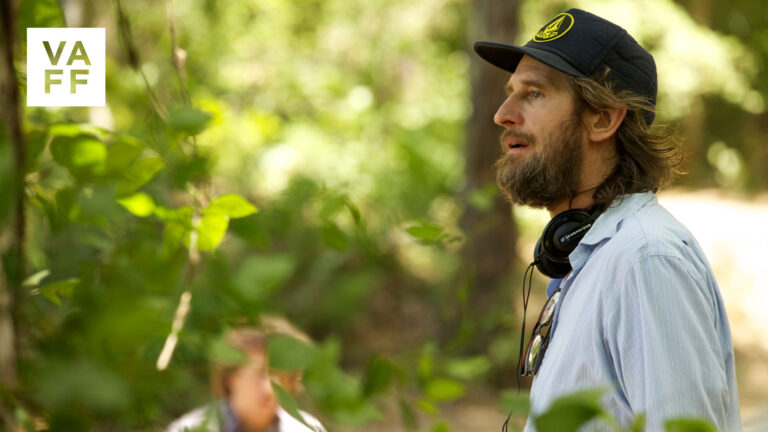 Ray McKinnon on set, wearing headphones and a baseball cap. VAFF logo.