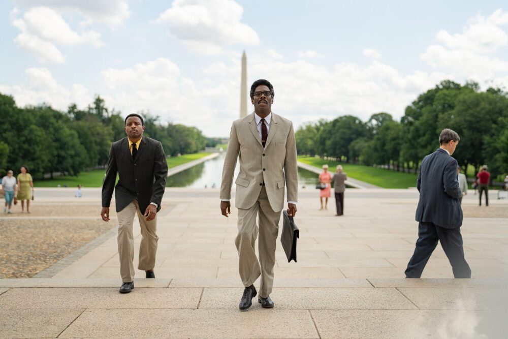 Scene from Rustin movie: Man in suit walks towards Washington Monument.