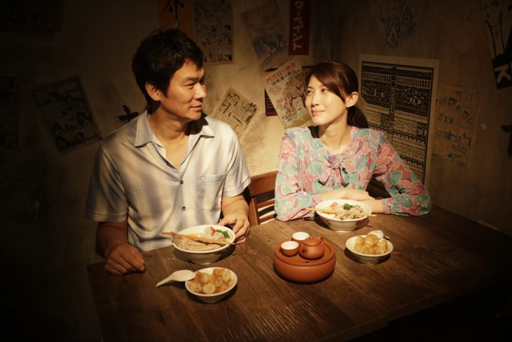 Couple enjoys ramen at a vintage-style ramen shop, sharing tea and a meal.