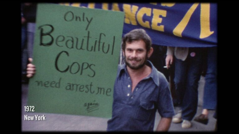 Man holding a sign that reads "Only Beautiful COPS need arrest me" at a 1972 New York demonstration.