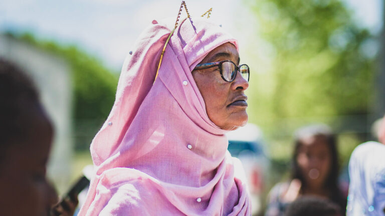 Woman in pink hijab and glasses at Refuge event