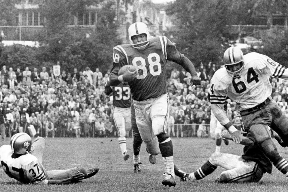 Football player #88 running with the ball, defenders closing in.