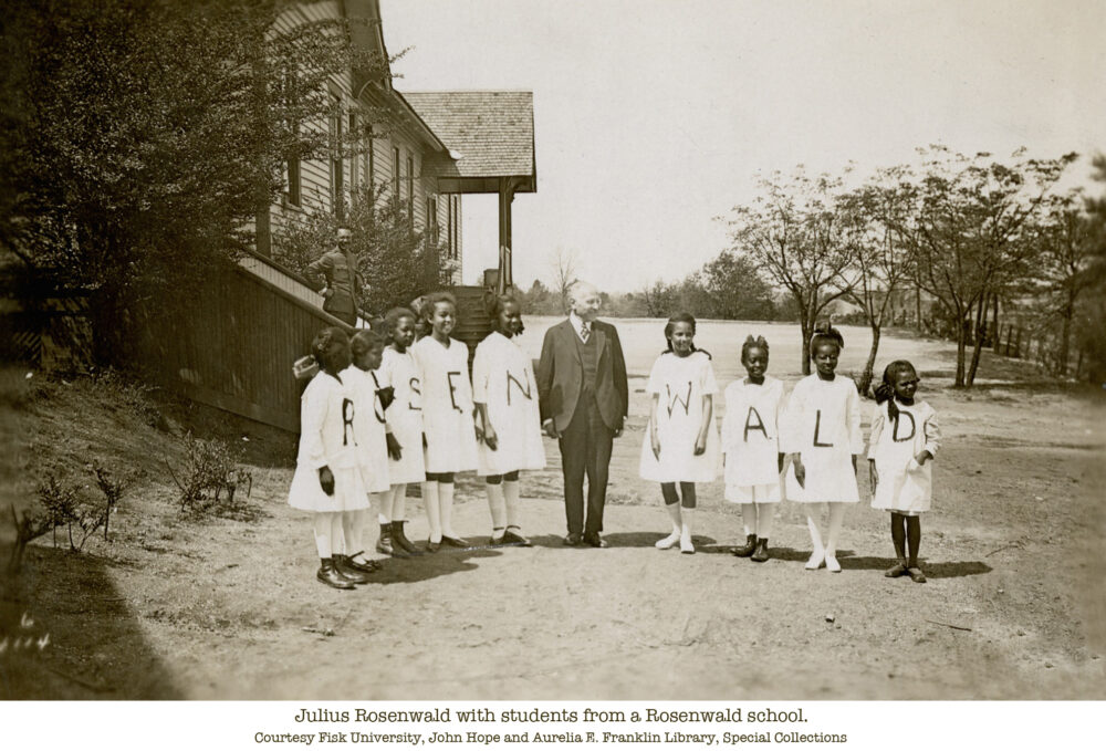 Julius Rosenwald with students outside a Rosenwald school. Students hold letters spelling "Rosenwald.