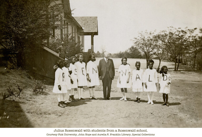 Julius Rosenwald with students outside a Rosenwald school. Students hold letters spelling "Rosenwald.