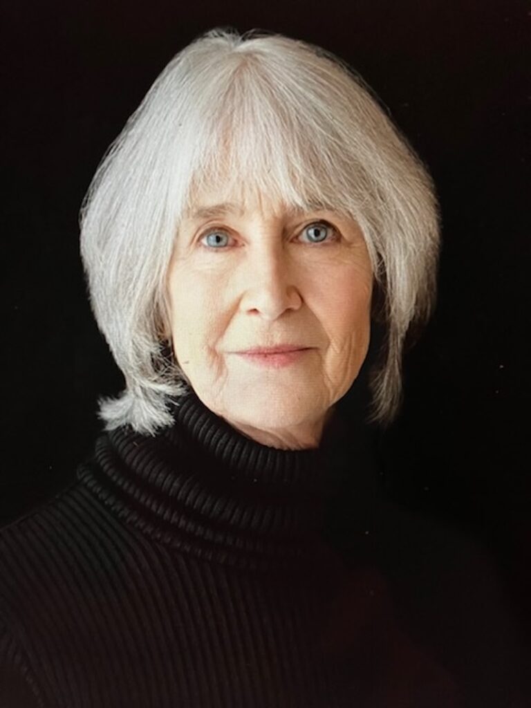 Portrait of author Roxana Robinson with striking blue eyes and silver hair.