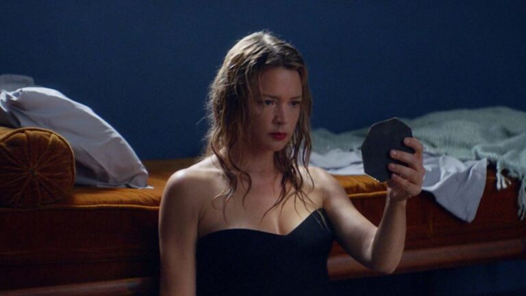 Actress Virginie Efira looking at a mirror shard in "Sibyl