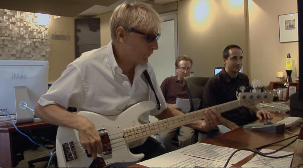 Coleman Mellett playing bass guitar in a recording studio.