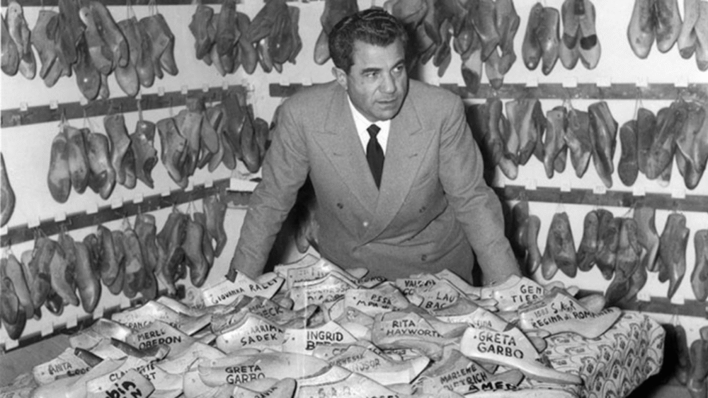 Salvatore Ferragamo surrounded by shoe lasts with celebrity names.