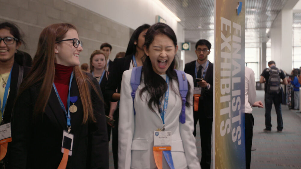 Excited students at a science fair finalists exhibit.