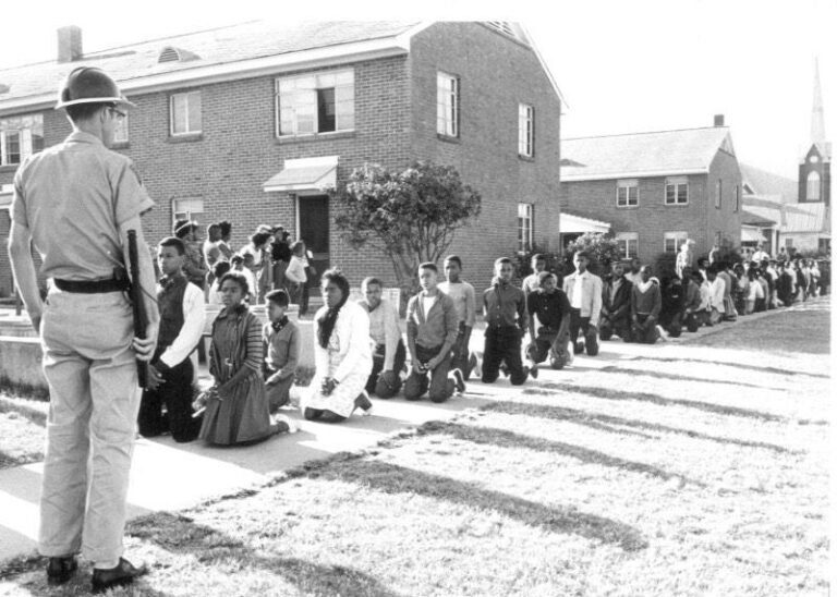Selma protest: Students kneel before a guard during the Civil Rights Movement.