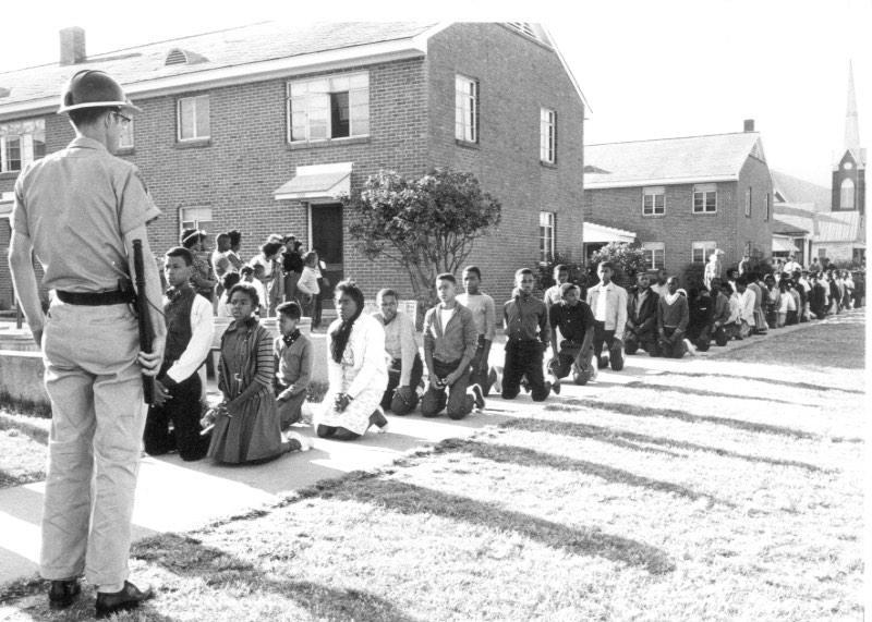 Selma protest: Students kneel before a guard during the Civil Rights Movement.