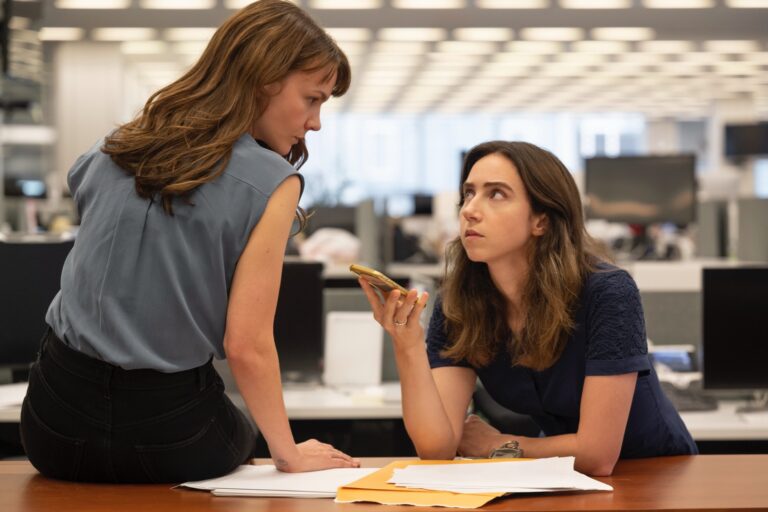 Carey Mulligan and Zoe Kazan in "She Said," discussing documents in an office.