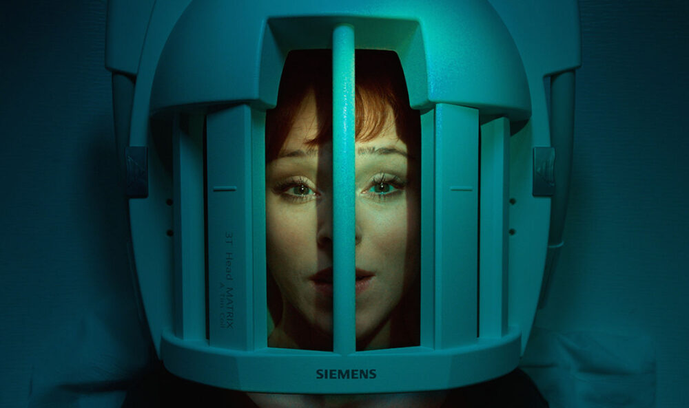 Woman's face inside a Siemens 3T Head Matrix MRI machine.