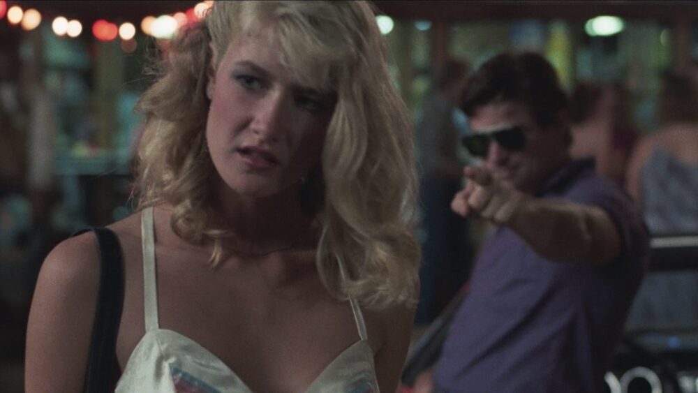 Laura Dern in "Smooth Talk" with a man pointing in the background.