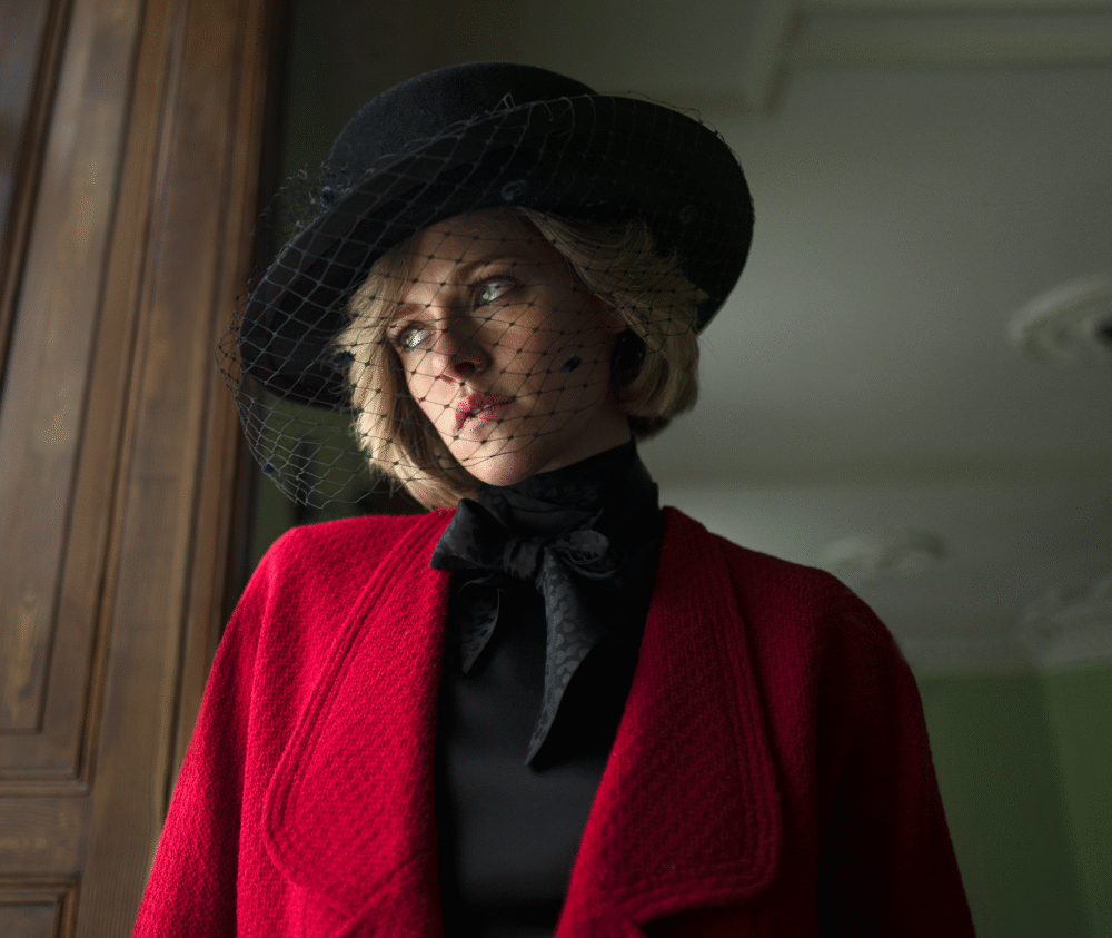 Kristen Stewart as Princess Diana in "Spencer," wearing a red coat and veiled hat.