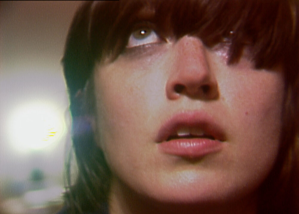 Close-up of a woman with bangs looking upwards.