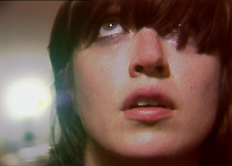 Close-up of a woman with bangs looking upwards.