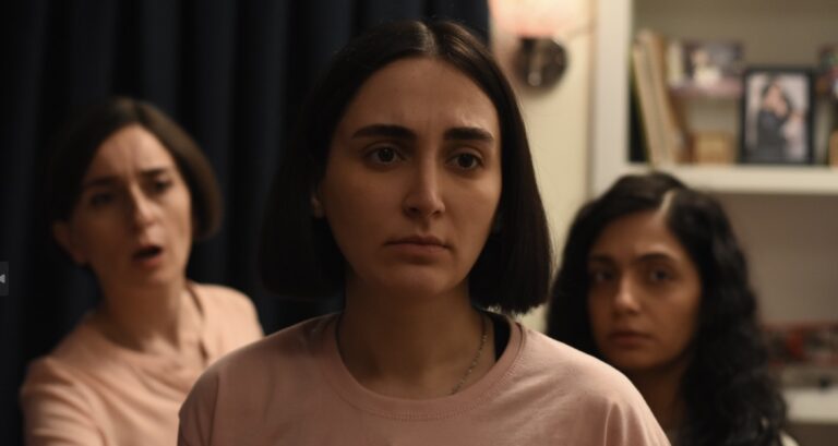 Three women with concerned expressions, likely related to "The Seed of the Sacred Fig.