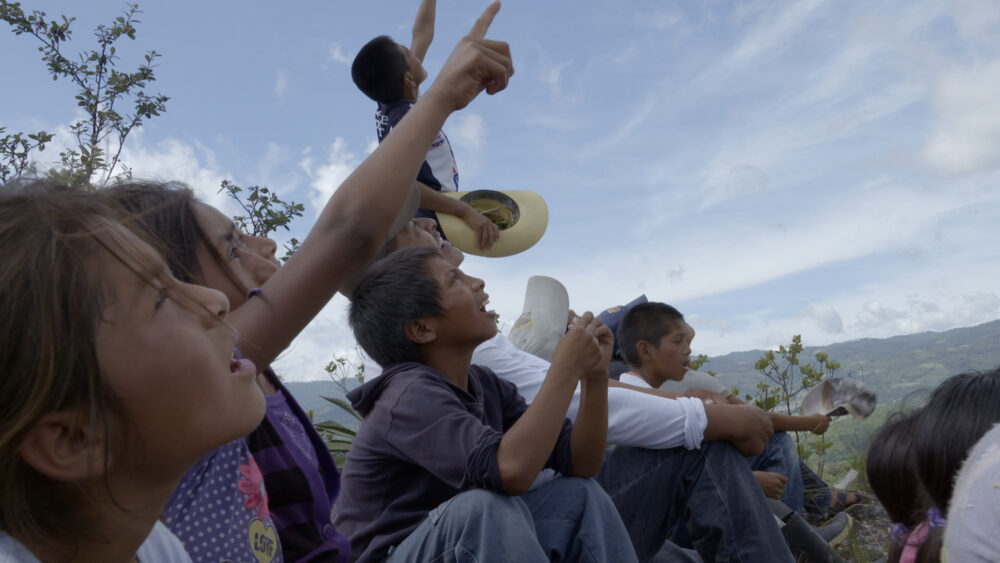 Children looking up at the sky, possibly watching "The Sower" in action.