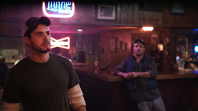 Man in a bar under a Miller Beer sign, possibly from "The Evening Hour" movie.