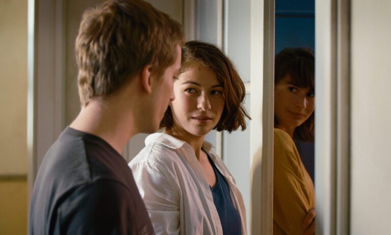 Young woman looking at a man, reflected in a mirror with another woman. "The Girl and the Spider.