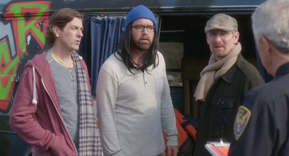 The Independents: Three men stand outside a graffiti-covered van.