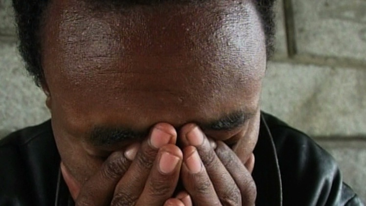 Man with head in hands, appearing distressed.