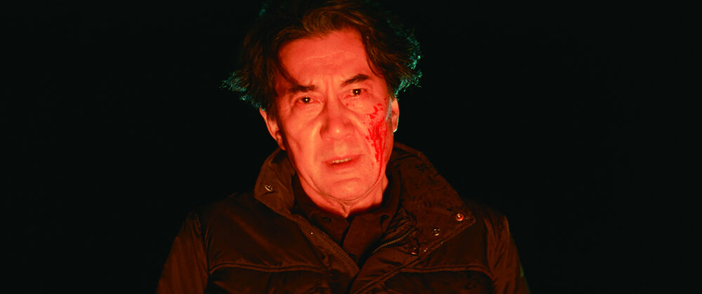 Man with a bloody face looking distressed in "The Third Murder" film.