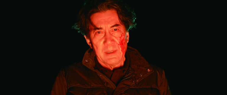 Man with a bloody face looking distressed in "The Third Murder" film.