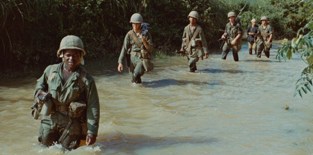 US soldiers wading through a river during the Vietnam War.