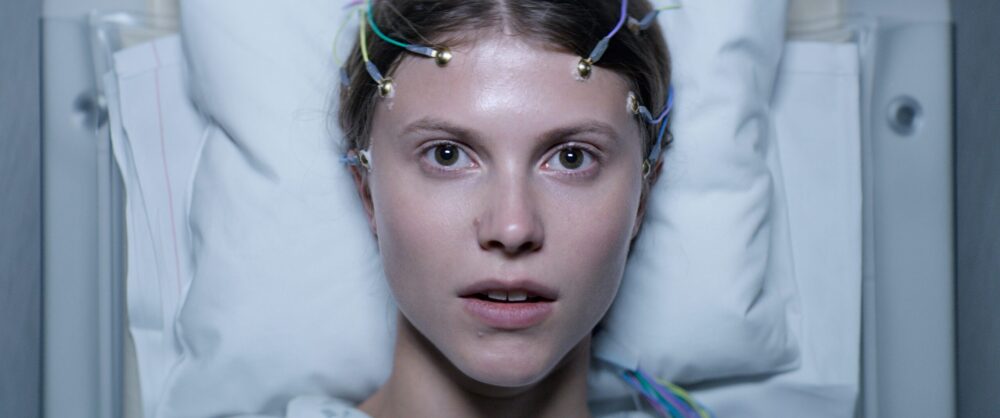 Thelma movie scene: Woman with electrodes attached to her head, lying in a hospital bed.