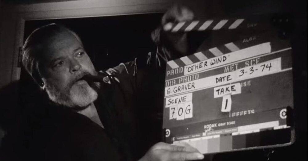 Orson Welles with a cigar holding a clapperboard for "Other Wind," dated 3-3-74.