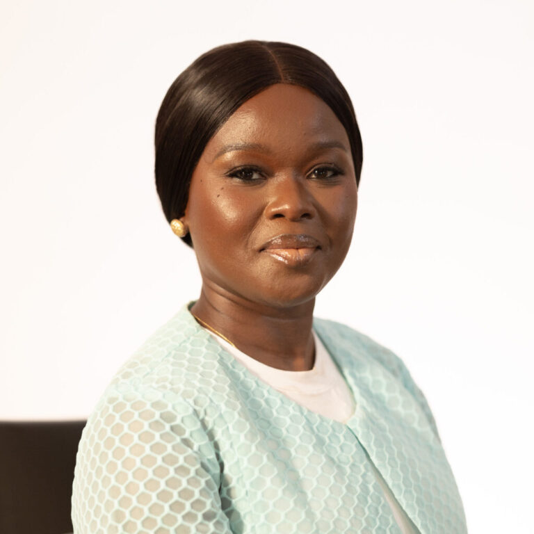 Toyosi Ogunseye, professional headshot with light blue jacket.