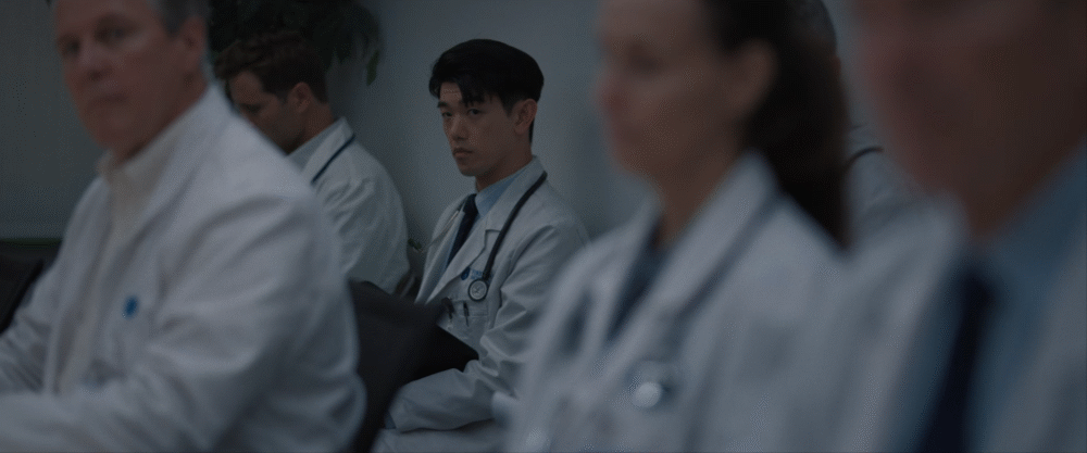 Doctor looking intently in a group of doctors wearing white coats.
