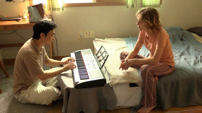 Man plays keyboard for a woman in a bedroom. A traveler's needs.