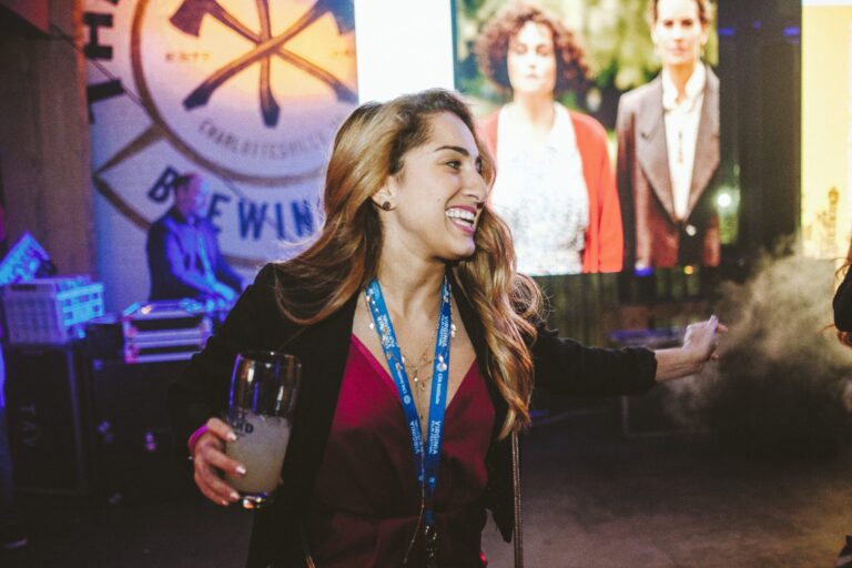 Woman at the 2019 Late Night Wrap Party holding a drink and wearing a Virginia Film Festival lanyard.