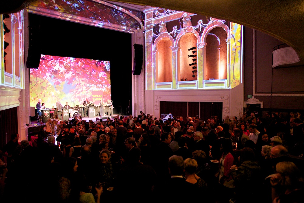 Gala opening night crowd enjoys live music under projected art.