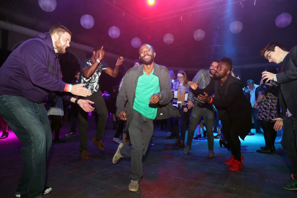 Enthusiastic group dancing at a late night wrap party.