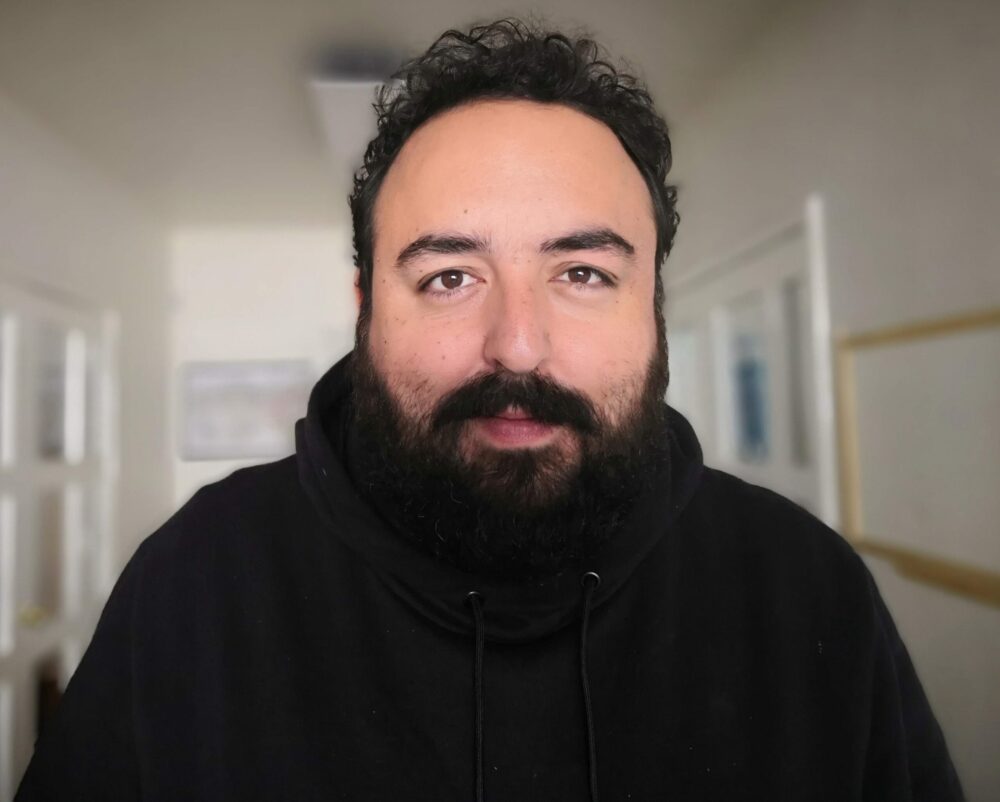 Headshot of Víctor Léycegui with a beard, wearing a black hoodie.