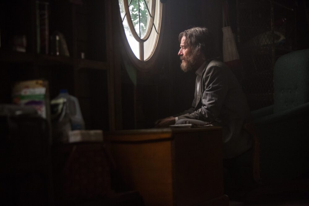 Bryan Cranston as Wakefield, sitting at a desk