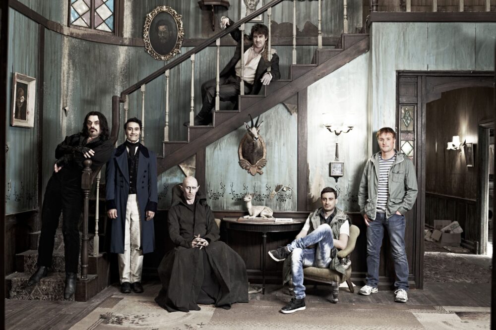 What We Do in the Shadows cast poses in a gothic home.