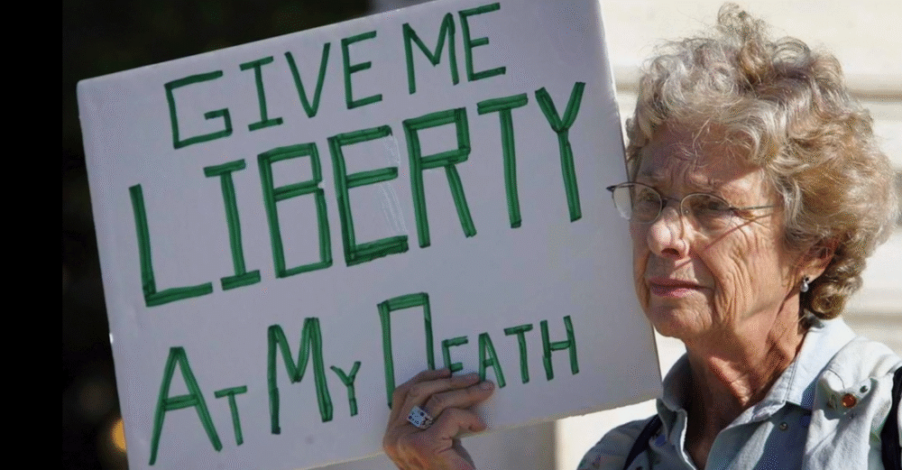 Elderly woman holding a sign that reads "Give me liberty at my death.