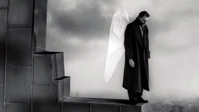 A man with angel wings standing on a ledge.