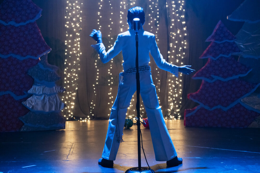Elvis impersonator performing on stage at Graceland.
