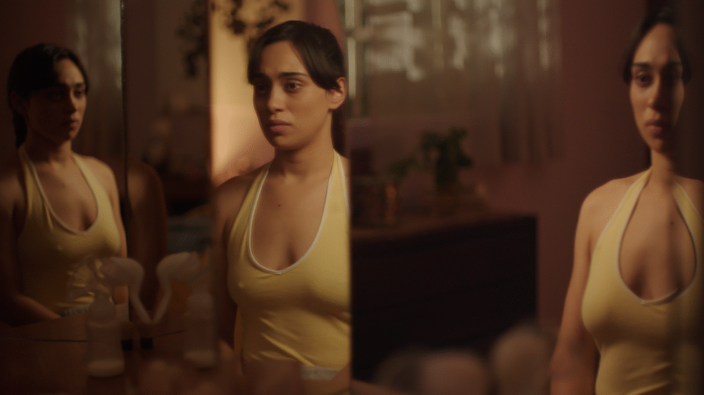 Woman in yellow tank top reflected in mirror, looking concerned.