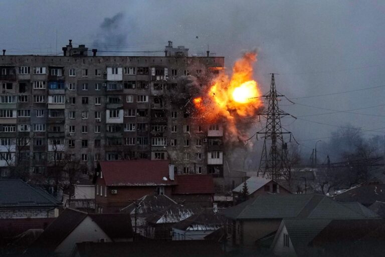 Explosion engulfs apartment building in Mariupol, Ukraine, during conflict.