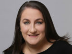 Liz Biber headshot, smiling with dark hair and a black top.