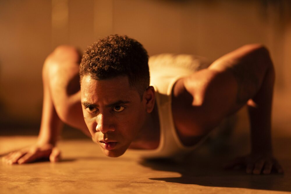 Man doing push-ups with focused gaze. Strength and determination.