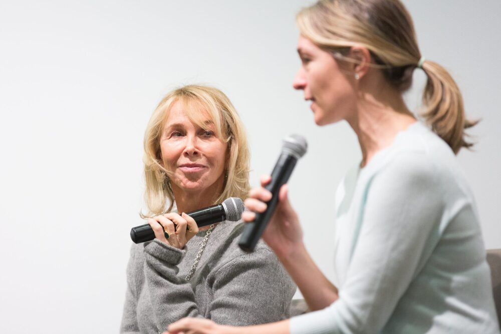 Two women speaking into microphones during a panel discussion.